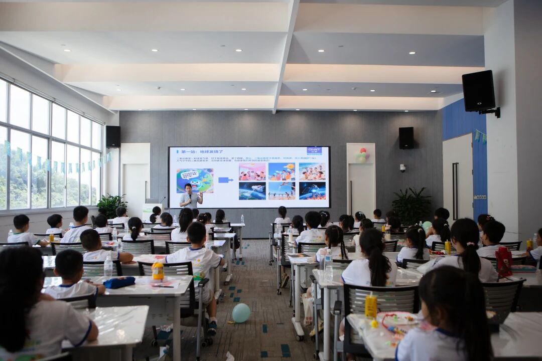 Children attending CHINT’s Green Family Day event, participating in an environmental education session with a sustainability-themed presentation in a classroom setting.