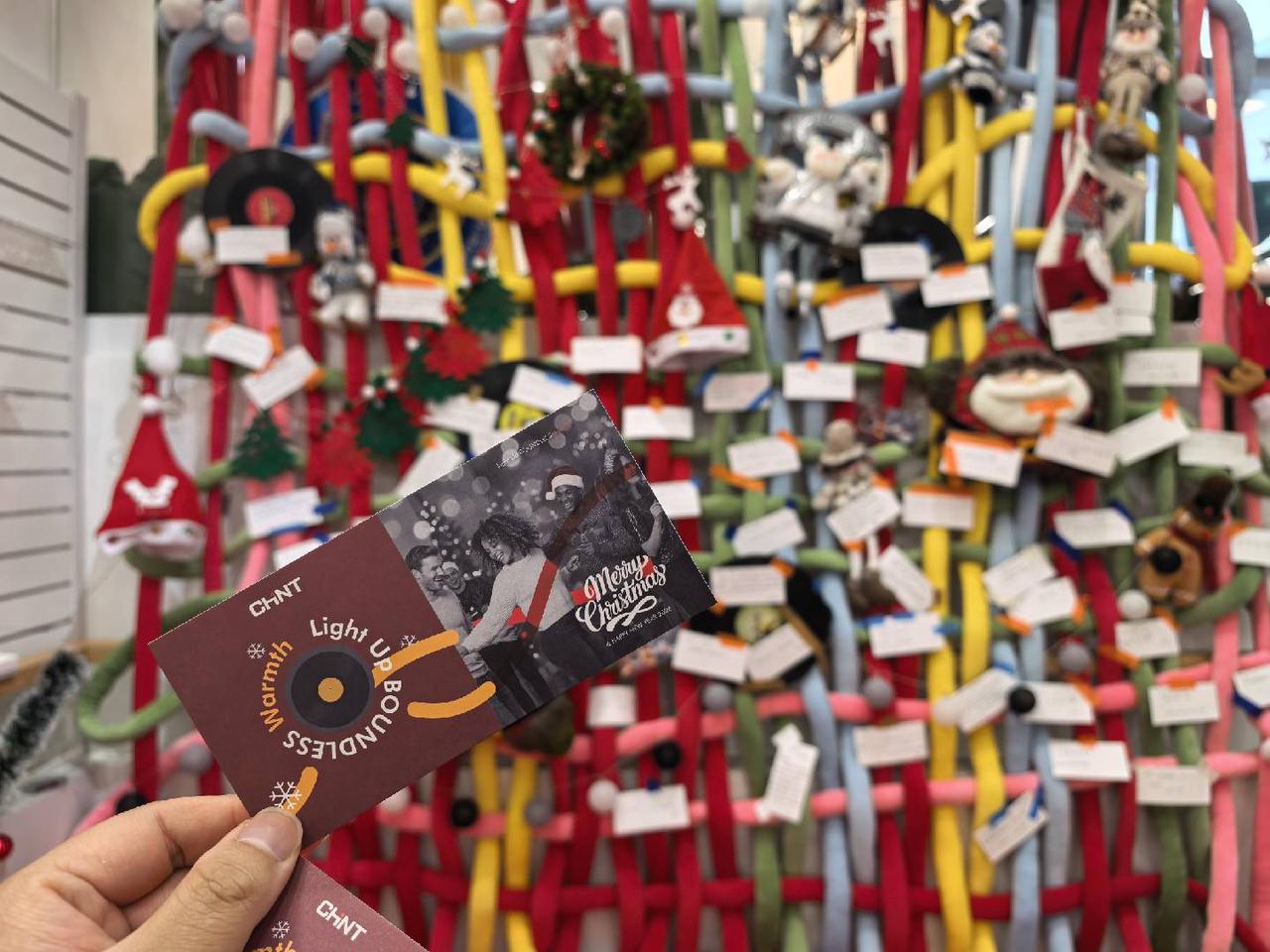 CHINT Christmas message cards displayed on a festive installation, sharing employee wishes under the “Light Up Boundless Warmth” theme