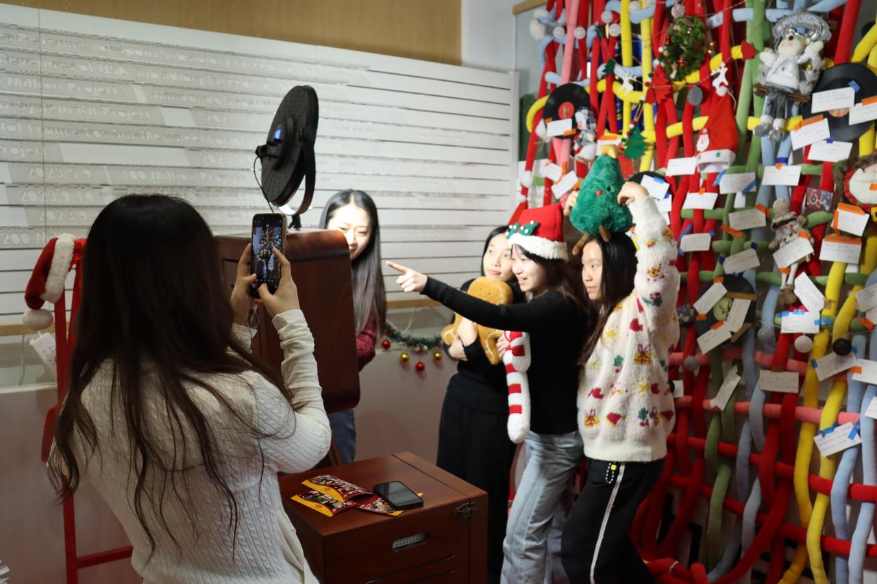 CHINT employees take photos at a Christmas vintage photo corner, enjoying creative and interactive holiday activities