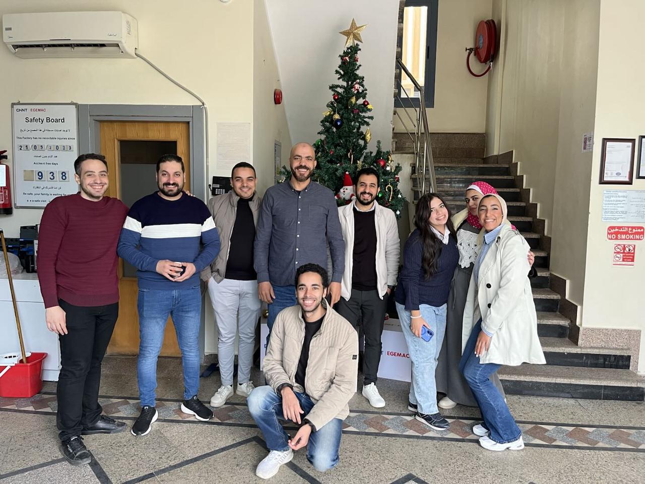CHINT Egypt team gathers by a decorated Christmas tree, celebrating the festive season with unity and smiles