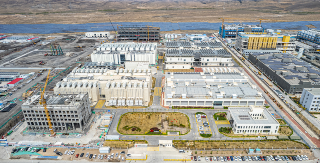 Aerial view of CHINT Electrics industrial campus with multiple factory buildings, solar panels, and construction sites