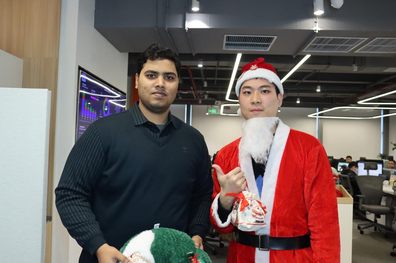 CHINT employees pose with a colleague dressed as Santa Claus during an office Christmas gift exchange celebration
