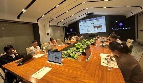 CHINT employees participating in an ESG training workshop, gathered around a conference table with laptops and a sustainability presentation displayed on screen.
