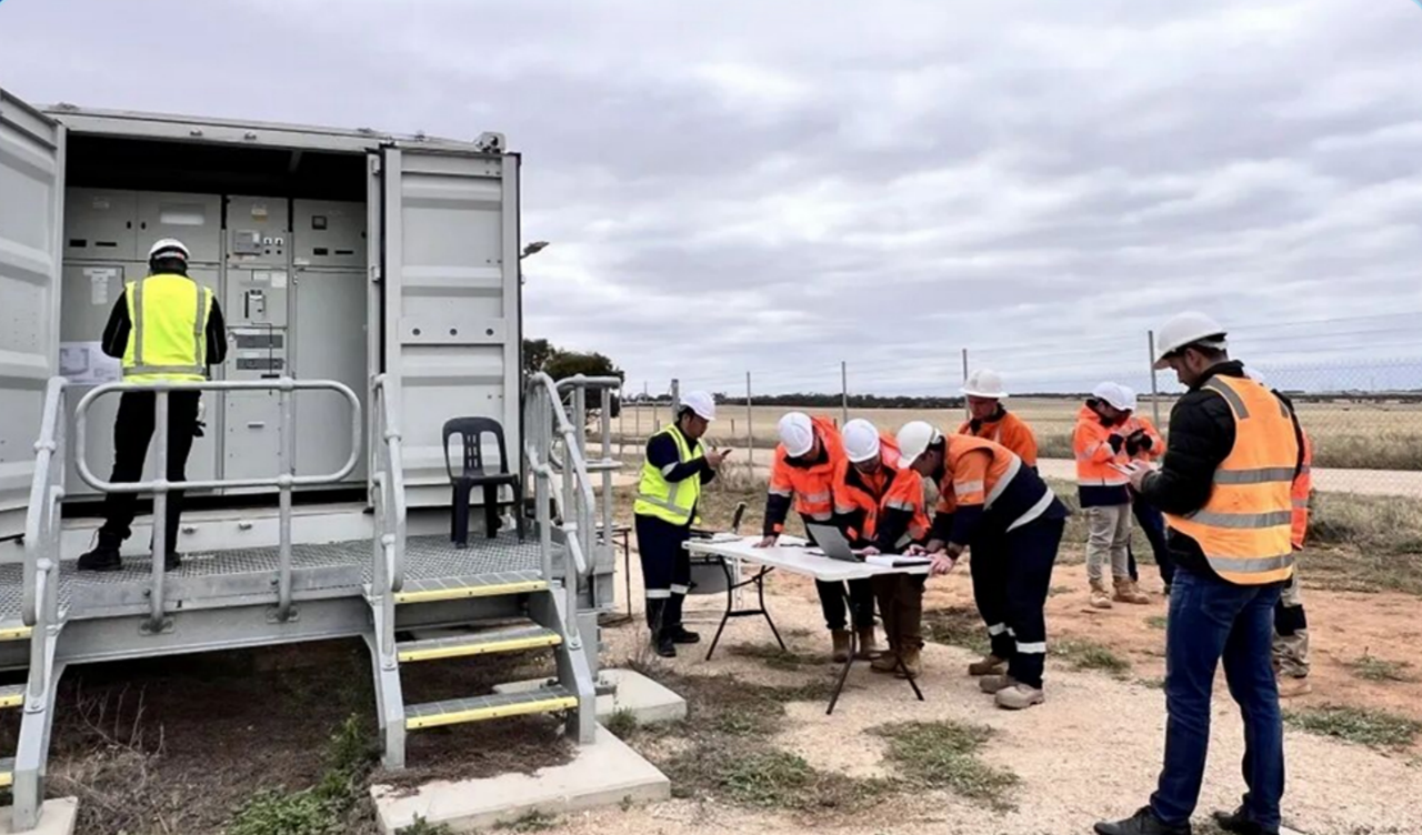 CHINT Electric field engineers inspecting and working on-site at an outdoor electrical facility, wearing safety vests and helmets