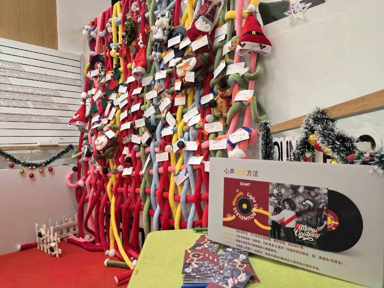 CHINT headquarters Christmas wish wall filled with employee messages, festive decorations, and the “Light Up Boundless Warmth” celebration theme