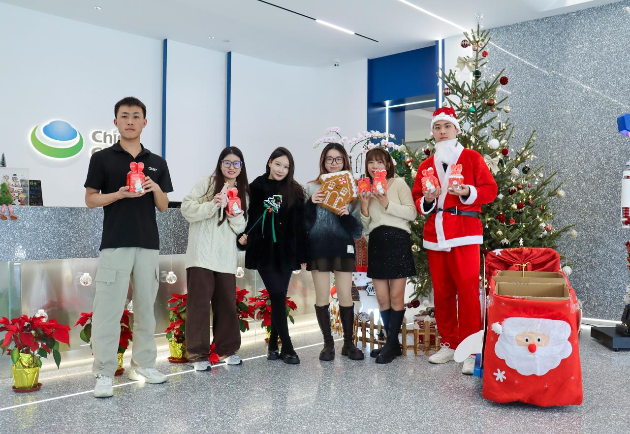 CHINT headquarters employees celebrate Christmas together, exchanging gifts and spreading holiday cheer beside a decorated Christmas tree