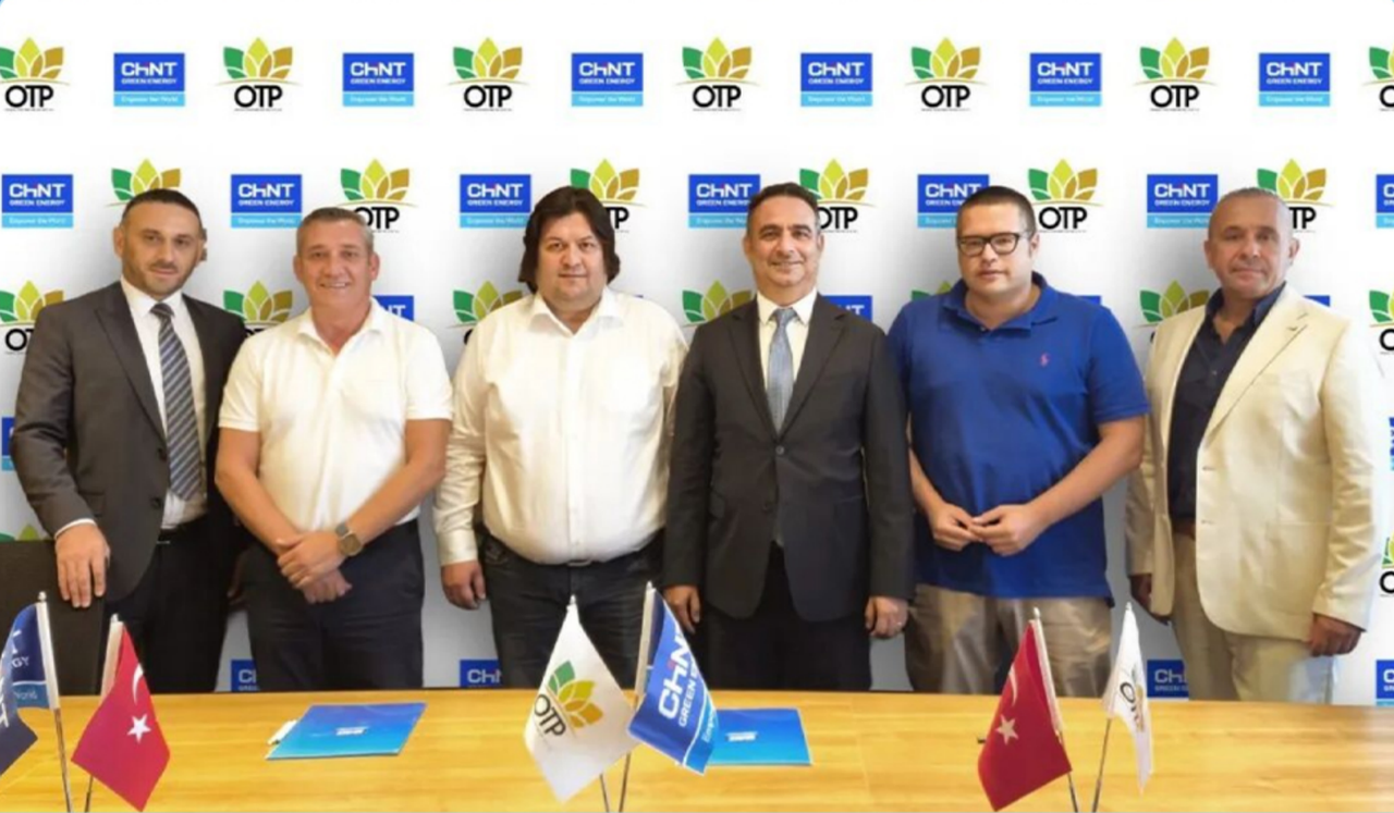 CHINT Electric and OTP executives posing for partnership signing photo with company logos in background