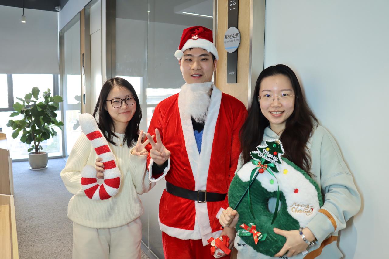 CHINT colleagues pose with a Santa Claus costume during office Christmas celebrations, sharing joy and holiday cheer