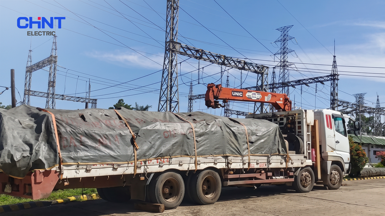 Project team standing in front of a high-voltage substation during nighttime commissioning work