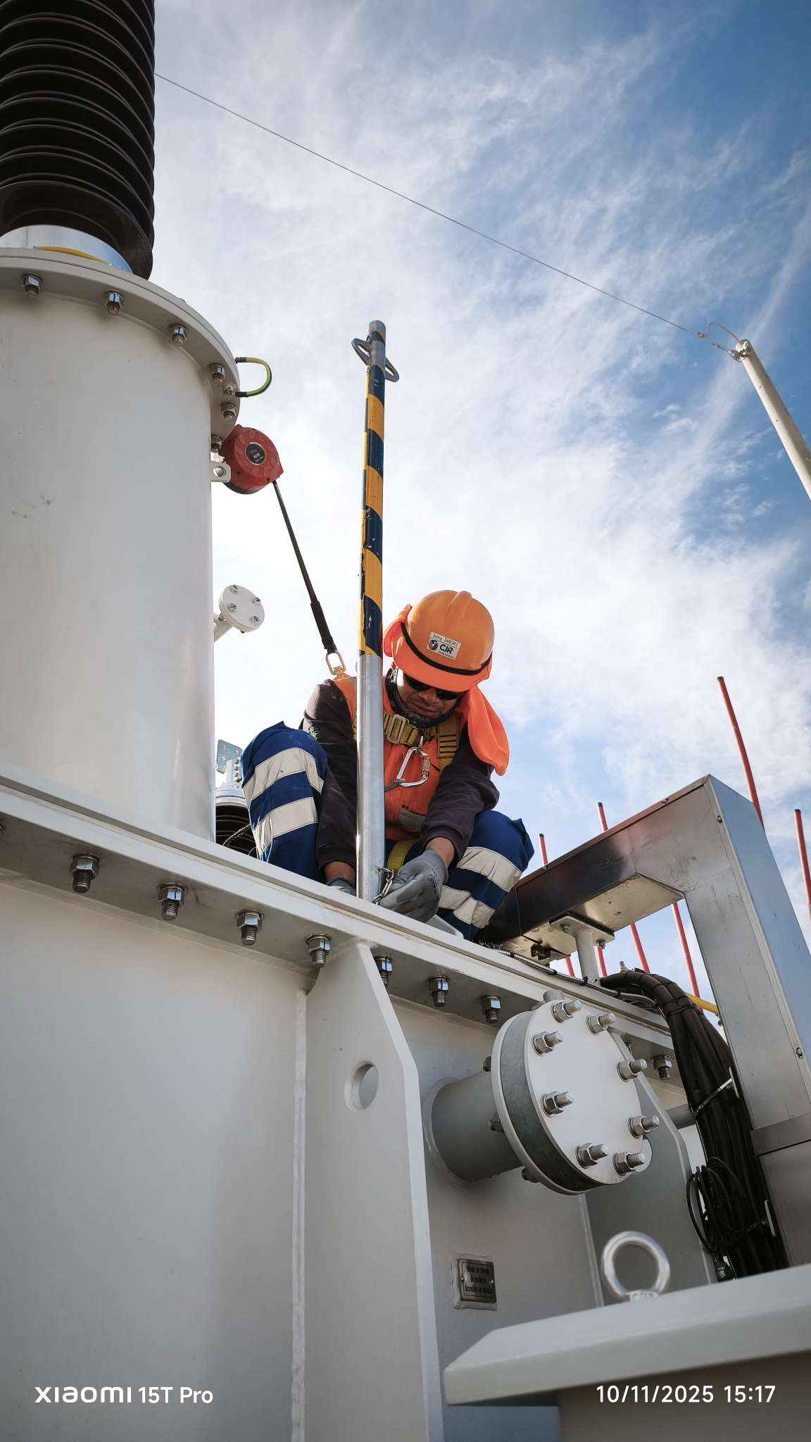 Electrical engineer wearing safety gear working on high-voltage power equipment