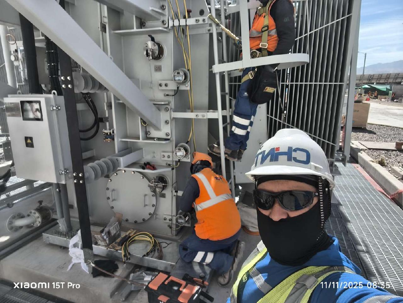 Technicians performing installation and maintenance work on a power transformer at an energy site