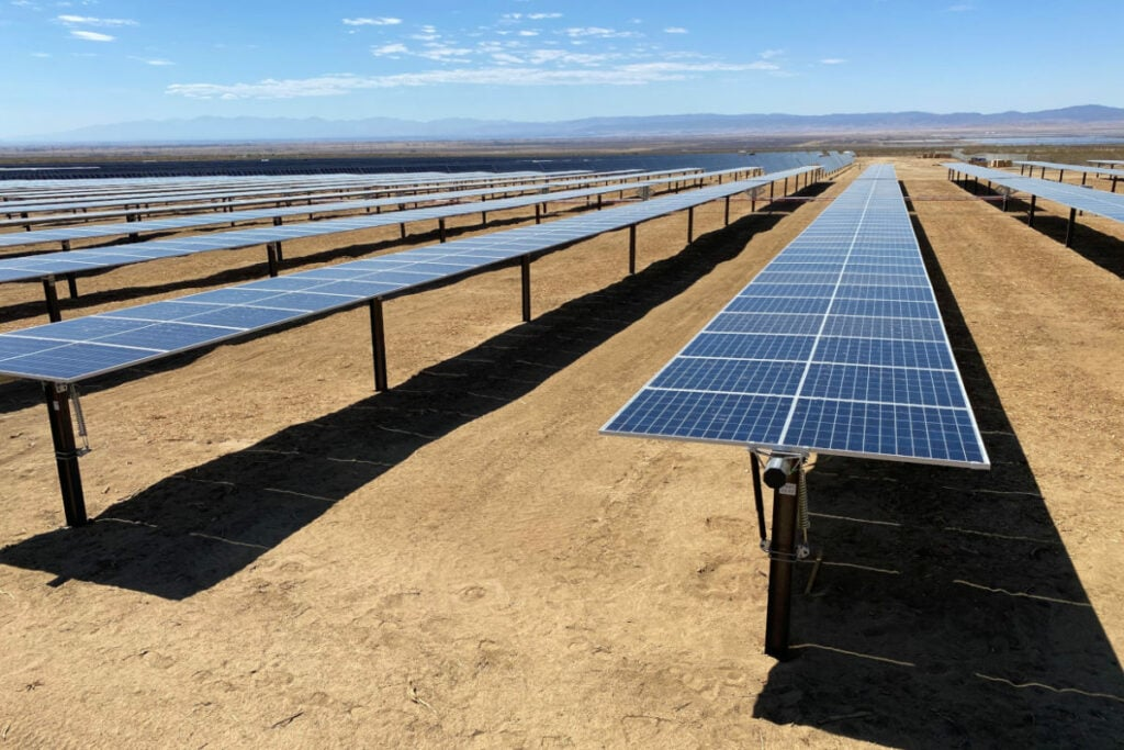 utility scale solar panel farm with rows of photovoltaic modules in a dry landscape